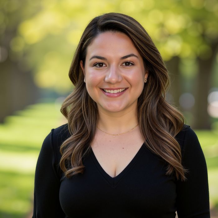 Outdoor professional portrait of Kathleen Guvercin, LMHC smiling in a park setting.