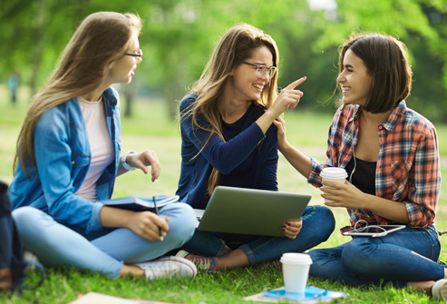 Teen girls sitting together outdoors during a supportive group workshop and wellness discussion.