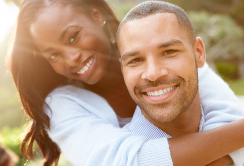 Smiling couple outdoors representing healing, emotional connection, and wellness through ketamine-assisted therapy.