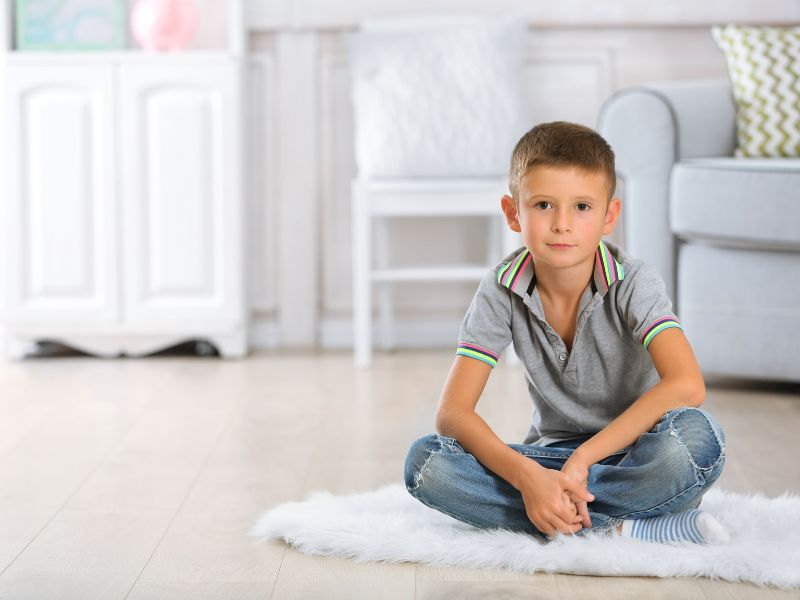 Frequently Asked Questions About Counseling | Pathways of Florida Young boy sitting in a comfortable home environment representing common questions about counseling and mental health support for children and families.